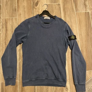 Stone island crewneck  - Säljer nu en stone island crewneck i storlek S, tröjan är i blå färg och skicket är 7/10 men det är 2 små hål, se bild 3.  Hör av er om ni har frågor!