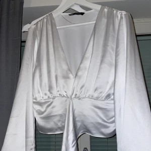 Vit silke blus - Fin vit blus. Dock har det råkat gått upp lite trådar på armarna!! 