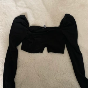Partytopp - Svart kort topp, men en trekants skurning underifrån. Lite puff på axlarna. Använd 2 gånger därav den säljs 