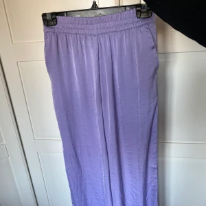 Lila byxor i satin - OANVÄNDA! Lila satinbyxor från H&M. Storlek: S. Köparen står för frakt, kan samfraktas med annat.