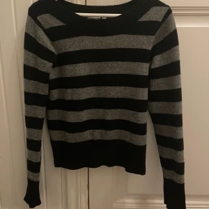 Randig tröja - Grå och svart randig stickad tröja från gina tricot! Säljer för inte använder. Tröjan har ett litet hål nere på vänster arm! Men inget som man inte kan fixa! Köpare står för frakt💕(39kr frakt)