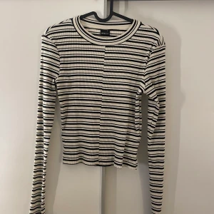 Randig Gina topp - En topp från Gina Tricot, aldrig använd, färgerna vit och svart randig.