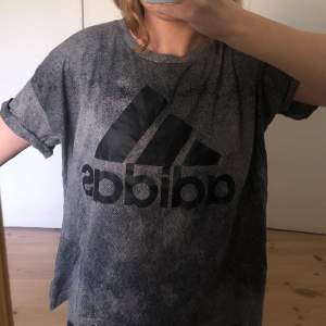 Adidas t-shirt, grå/svart med ett svart adidasmärke. Oanvänd, bra skick!