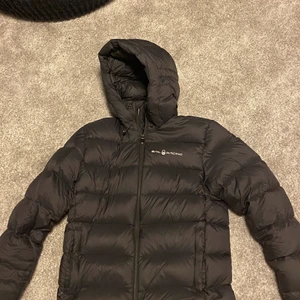 Sail racing puffer jacket - Svart Sail Racing Dunjacka i storlek Medium. Skicket är 9/10 bortsett från ett litet hål som har lagats och inte är synligt på vänster arm. Säljer p.g.a att den inte används men har bara använt fåtal gånger förra vintern. Nypris: 3500 kr 