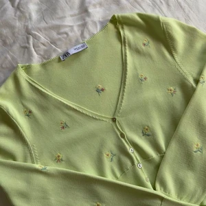 Grön kofta med blimmor - Supersöt grön kofta med blommor från zara. Använd fåtal gånger - den är som ny. Färgen visas bäst på bild 1 och 2.