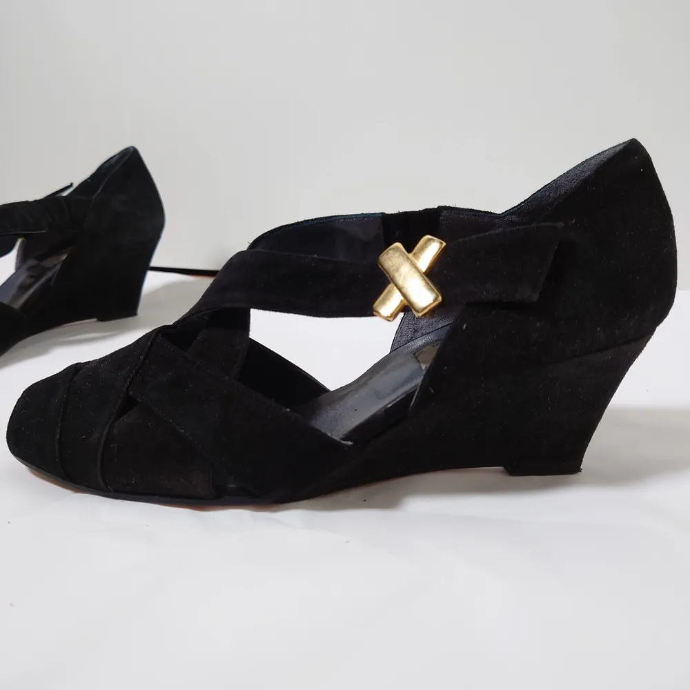 Svarta, äldre skor med tunn, ganska hög klack och gulddetaljer. Innehåller äkta läder🌿. Skor.