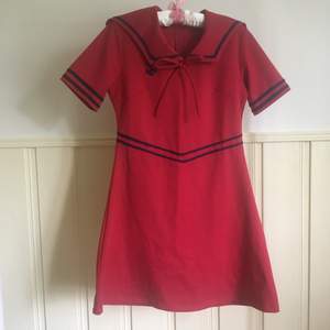 Röd seglarklänning med mörkblå detaljer. I gott skick. Från pop boutique/pop England. Storleken ”2” skulle jag uppskatta som S-M. 
