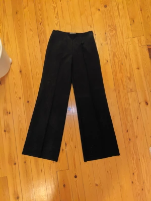 Kostymbyxor Bootcut  - Baggy och vida kostymbyxor med coola broderade detaljer, säljer då de är lite för små för mig :( står ingen storlek men skulle säga att de sitter som 29/33