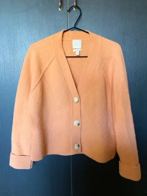 Mjuk kofta - Säljer denna orangea kofta från H&M. Otroligt varm och mjuk och boxning fit. Armarna är ganska långa och går även att vika upp. 