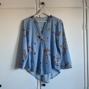 Blommig blus  - Blå blus med beiga blommor på i storlek S. Mycket bra skick!