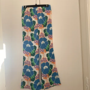 Flowiga Zara-byxor - Fina mönstrade byxor från Zara i ett flowigt och lätt material. Fickor bak och resår i midjan. Utsvängda ben. Storlek M:)