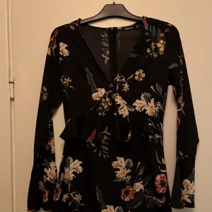 Somrig figursydd klänning - Så härlig blommig sommarklänning med volang i midjan och vida armar. Använd 2 gånger enbart då den är på gränsen för liten för mig, hoppas någon annan kan bära upp den bättre så den kommer till användning. 