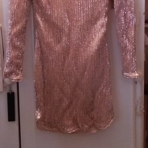 Paljettklänning  - Ljust rosa paljettklänning med bar rygg. Storlek 40, aldrig anvånd, alla lappar kvar. 