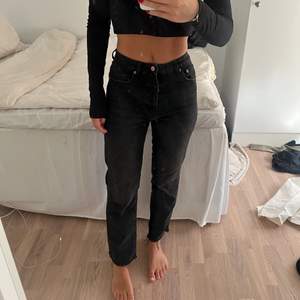 Svarta jeans med slitna ändar