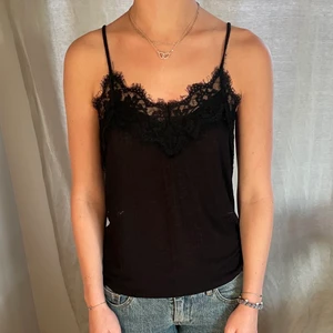 Svart zara linne med spetskant - Jättefint svart linne med spetskant från zara. Köpt för 2år sedan men väldigt bra skick.