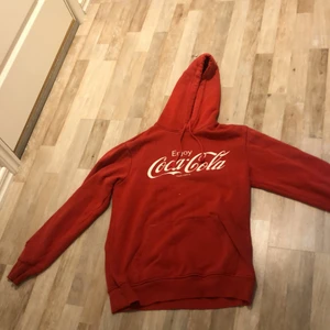 Coca-Cola hoodie  - En cool röd Coca-Cola hoodie från HM. Storlek S. Använd fåtal gånger. Har ett hål på ena armen men inget som syns särkilt mycket vid användning:) nypris ca 199kr men säljer för 50kr 