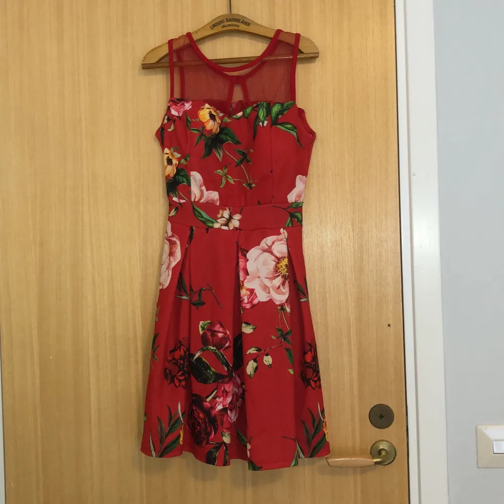 Röd klänning med blommor köpt på mallorca för flera år sedan. Dock aldrig använd. . Klänningar.