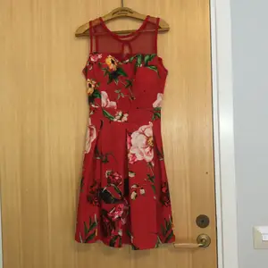 Röd klänning med blommor köpt på mallorca för flera år sedan. Dock aldrig använd. 