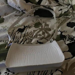 Vit liten hand/axelväska - Säljer denna väska för 40 kr med 50 kr frakt! Har haft den i 1 år men knappt använt eftersom jag inte tyckte den var för mig. Fint skick.