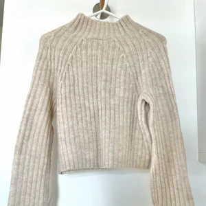 Stickad cropped tröja - Beige stickad långärmad croppad tröja. Använd ett få tal gånger. Kortare i magen. Högre i kragen. Passar XXS-XS