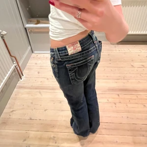 Lågmidjade True Religon bootcutjeans - As coola mycket lågmidjade mörkblåa true religon jeans! Dom ser inte jätte bootcut ut på bilden men det är därför de är för långa för mig vilket också är anledningen till varför jag säljer. Köpt second hand för 1000kr