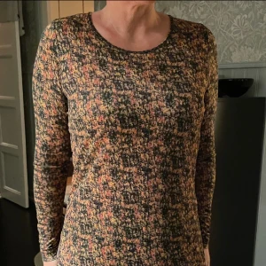 Dagmar klänning - DAGMAR Klänning Storlek: S (går M också) knälång Material: 100% Lyocell Färg: svart/gul/röd mönstrad Skick: väl använd, sliten i banden i nacken där man knyter med syns inte så mycket då man knyter där (se bild)