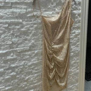 Klänning - Otrolig fin och kort paljettklänning med en arm och en öppning vid armen. Använd endast en gång en kort period. 