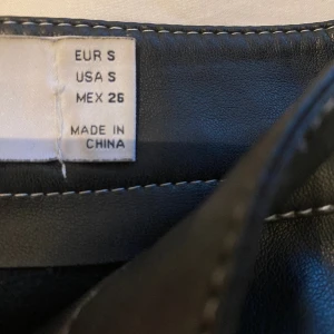 Oversized läder byxor med vit sömn - Riktigt fina byxor, passar till en hel del fest outfits. Köpta för 550kr
