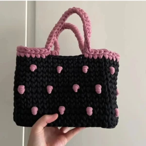 Bucket bag - Otroligt söt virkad rosa-svart bucket bag. Virkad med bomullsgarn från modeindustrins rester. höjd: 18 cm (29cm inkl handtag) bredd: 25cm djup: 8.5cm  OBS! Katt finns i hemmet