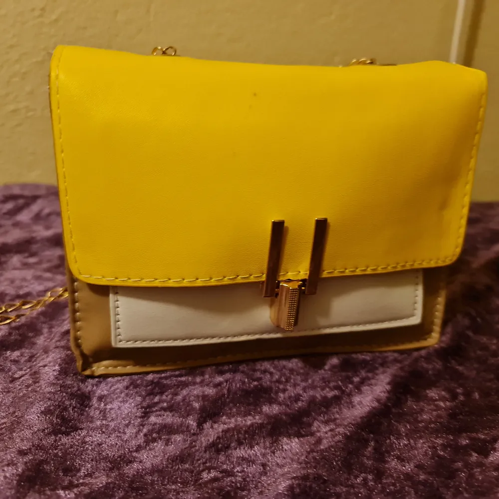 Liten gul väska. Helt enkel och det finns ingen separate rum på insidan.  Helt ny inte använt💛. Väskor.
