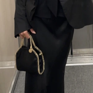 Stella mccartney väska - Säljer nu min strlla mccartney väska i ”tiny” modellen då jag tyvärr har för många väskor och den ej kommer till användning🥹 Super fin i svart med guldfärgade kedjor, knappt använd så inga skador, pris kan diskuteras vid snabb affär🩷