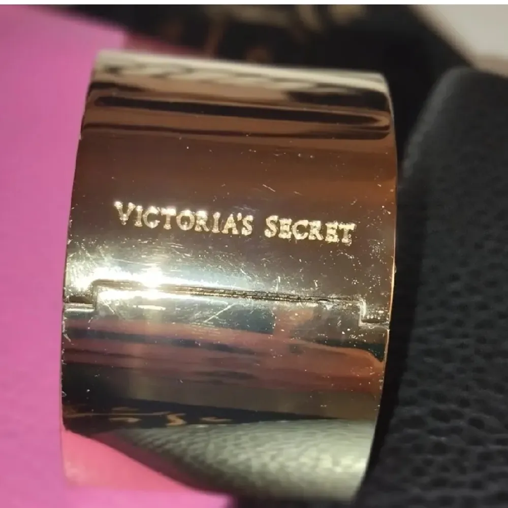 Victoria`s Secret armband i guld med nitar finns nån liten repa men annars i fint skick. Accessoarer.