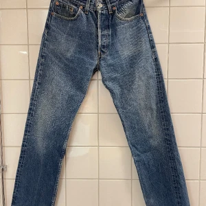 Levi’s 501 32/32 - Ett äldre par 501’or med fin tvätt samt Made in U.K. Troligtvis 90-tal på brallorna. Svårt att tyda storleken från tagen men ser ut att vara 32/32, passar mig perfekt som är 32a i midjan. Skickar gärna fler bilder. Pris alltid öppet för diskussion:). 