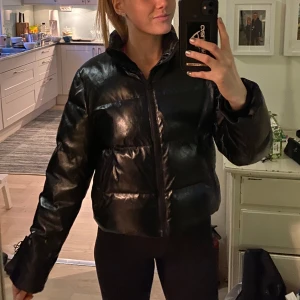 Jacka - Svart glansig jacka från weekday med dragkedjeficka. Fint skick utanpå, syns att den är använd inuti 