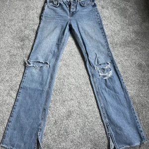 Bootcut jeans - Bootcut jeans med slit längst ner från pull & bear. Lite nedtrampade längst ner men inget som syns när man har de på sig. Skriv för mått eller fler bilder!