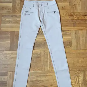 Beiga jeans med fake fickor, helt oanvända, storlek L men passar nog bättre M eller S