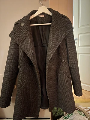 Kappa - Halvlång kappa från pimkie går till typ halva låret. Använd men har inga slitningar eller fläckar. Två extraknappar följer med.