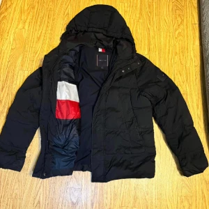 Tommy Hilfiger - Säljer min killes vinterjcaka som han köpte förra vintern. Endast använd en vinter.  Inga skador eller slitage och är i väldigt fint skick. Köptes från boozt hemsida för 3500kr  Pris kan diskuteras vid snabb affär 