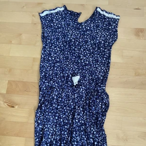 Byxdress - Blommig byxdress i storlek 164. Bra skick förutom att knäppningen är trasig, se bild 2, men är dock lätt att laga.