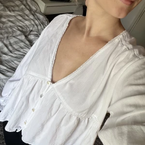 Vit blus - Vit blus från pull and bear i storlek M, sitter såhär på mig som vanligtvis har storlek 36/38. Har små spetsdetaljer vid bysten. Använd ett fåtal gånger. 🤗