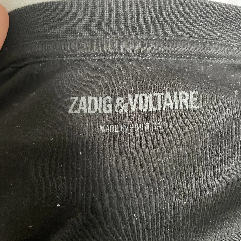 Svart Zadig & Voltaire t-shirt med sammet tryck. Knappt använd och i nyskick. Storlek medium men skulle säga att den är liten i storleken och mer som en lite större small. Köparen står för frakten.. T-shirts.