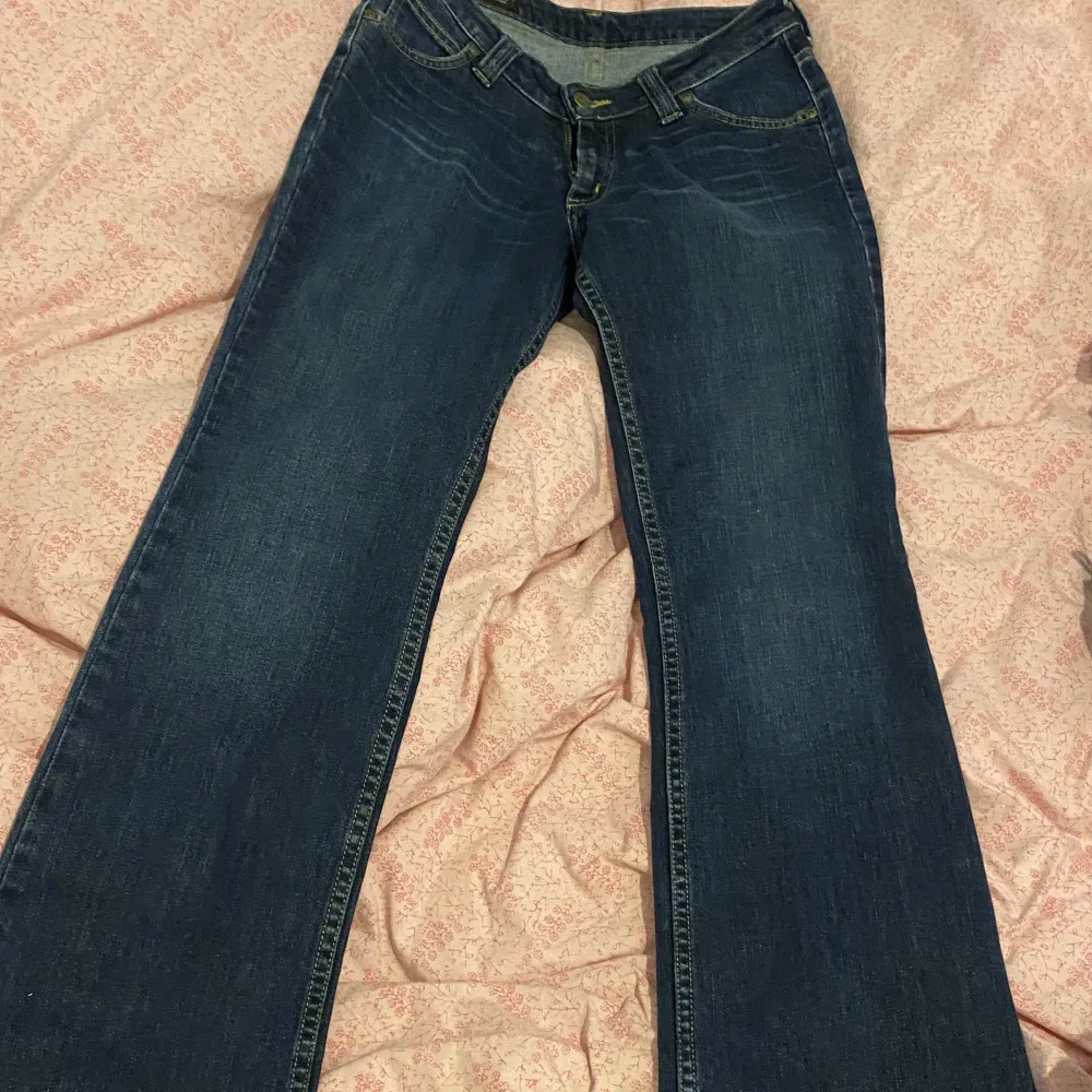 Ett par lågmidjade bootcut jeans ifrån märket lee. Storlek 28/33 och i en fin mörkblå nyans. Jeansen är i fint skick och är i ett stretchiga material. Lånade bilder men samma modell, dessa är i en mörkare nyans! Modellen heter Desoto. Jeans & Byxor.