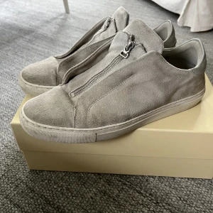 Arigatos  - Tja! Säljer ett par välanvända arigatos med zip! Finns en liten olje fläck på insidan som jag tror går bort med mocka tvätt eller nåt annat, kom privat för fler bilder det är stl 44. MVH Simon