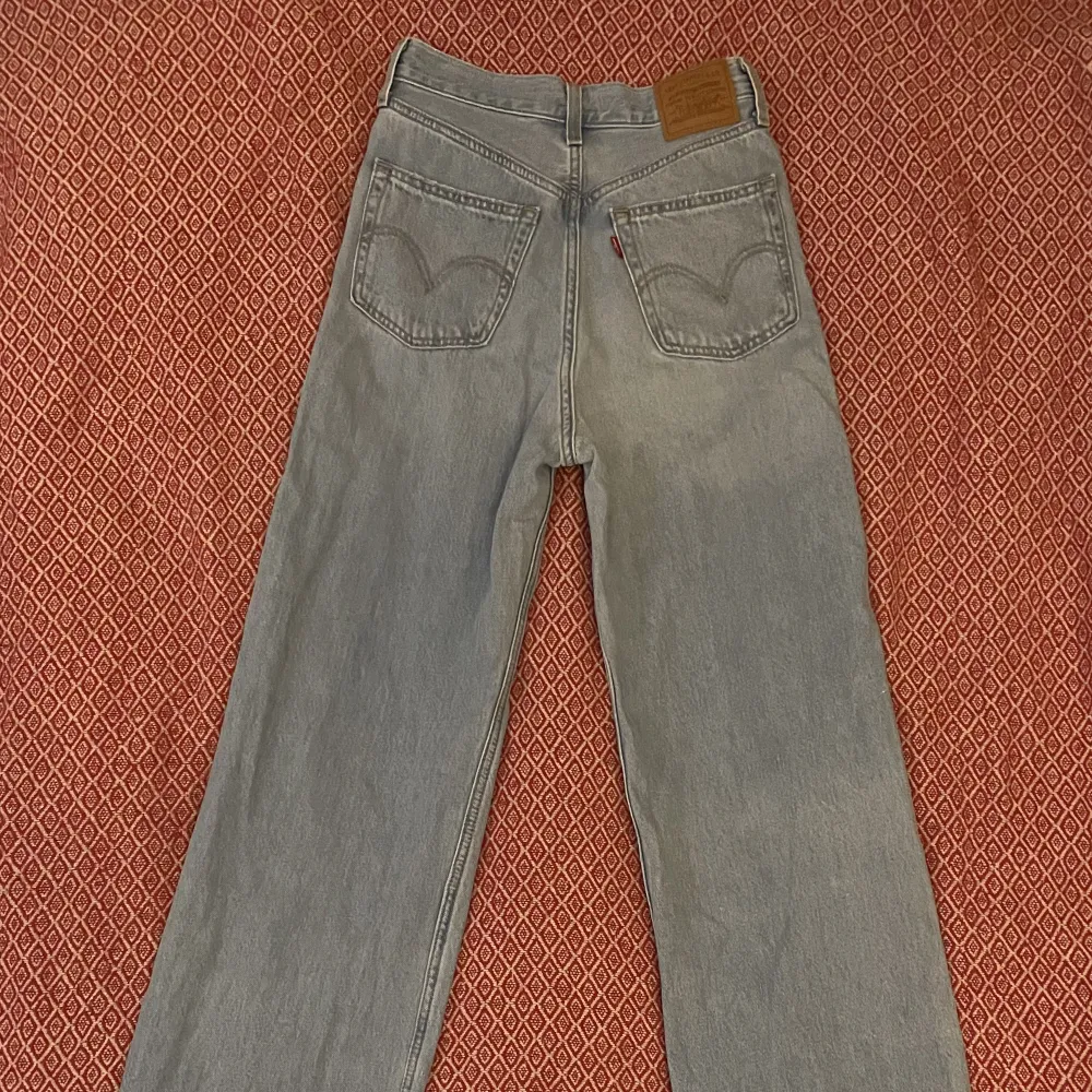 Hög midja och vida ben. Ljusblå Levi’s jeans i strl 25 - midja 25, längd 33.  Köpta för 1695 kr. Endast provade och tvättade en gång.. Jeans & Byxor.