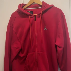 Jordan kofta - Detta är en röd jordan kofta som jag köpt för 700 kr. Den är tunn och skön under sommaren. Den är i väldigt god skick och jag köpte den under jullovet men har inte använt den.