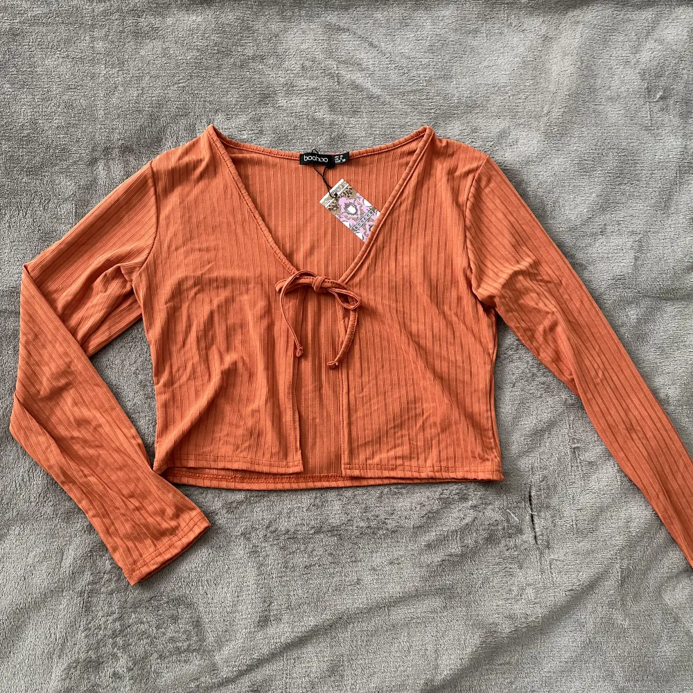 Aldrig använd, har 3 stycken likadan. Orange långärmad tröja med knytning fram, storlek 38🤍 Köpare står för fraktkostnaden!. Tröjor & Koftor.