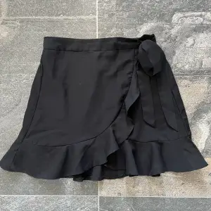 Säljer en svart kjol med volang och snörning. Använd ett fåtal gånger:)