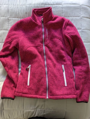 True North jacka - Vintät tjocktröja i rosa. Strl M  Väldigt sparsamt använd står emot vind väldigt bra. 
