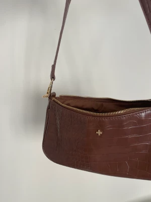 Brun handväska i fejk snake skin  - Superfin brun väska, bra skick, dragkedjan funkar toppen. 