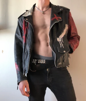 Punk bikerjacka i läder - Kolla vilken snygg jacka!! Äkta läder, sliten men hel och go, bortsett från fodringen som har nåt hål här och var. Ingen aning om märke eller årtal men av egen erfarenhet säger jag 80-talssydd. Märket på ryggen är påsytt och går att ta bort! 